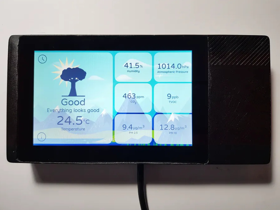 En smart enhet för övervakning av luftkvalitet visar detaljerade mätvärden för CO2, partiklar och temperatur på en pekskärm.