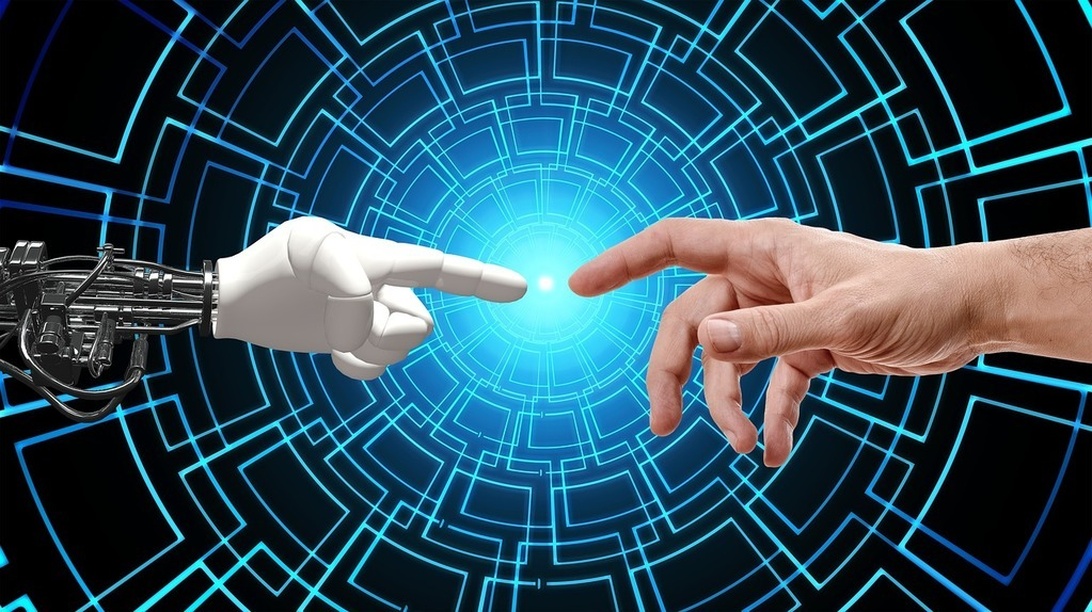 En robothand och en mänsklig hand sträcker sig mot varandra mot en blå digital bakgrund, symboliserande interaktion och partnerskap mellan människa och AI.
